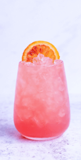 Delicious pink cocktail garnished with a refreshing orange slice.